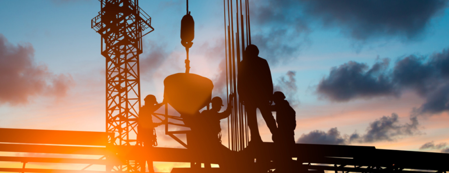 men hoisting equipment on construction site